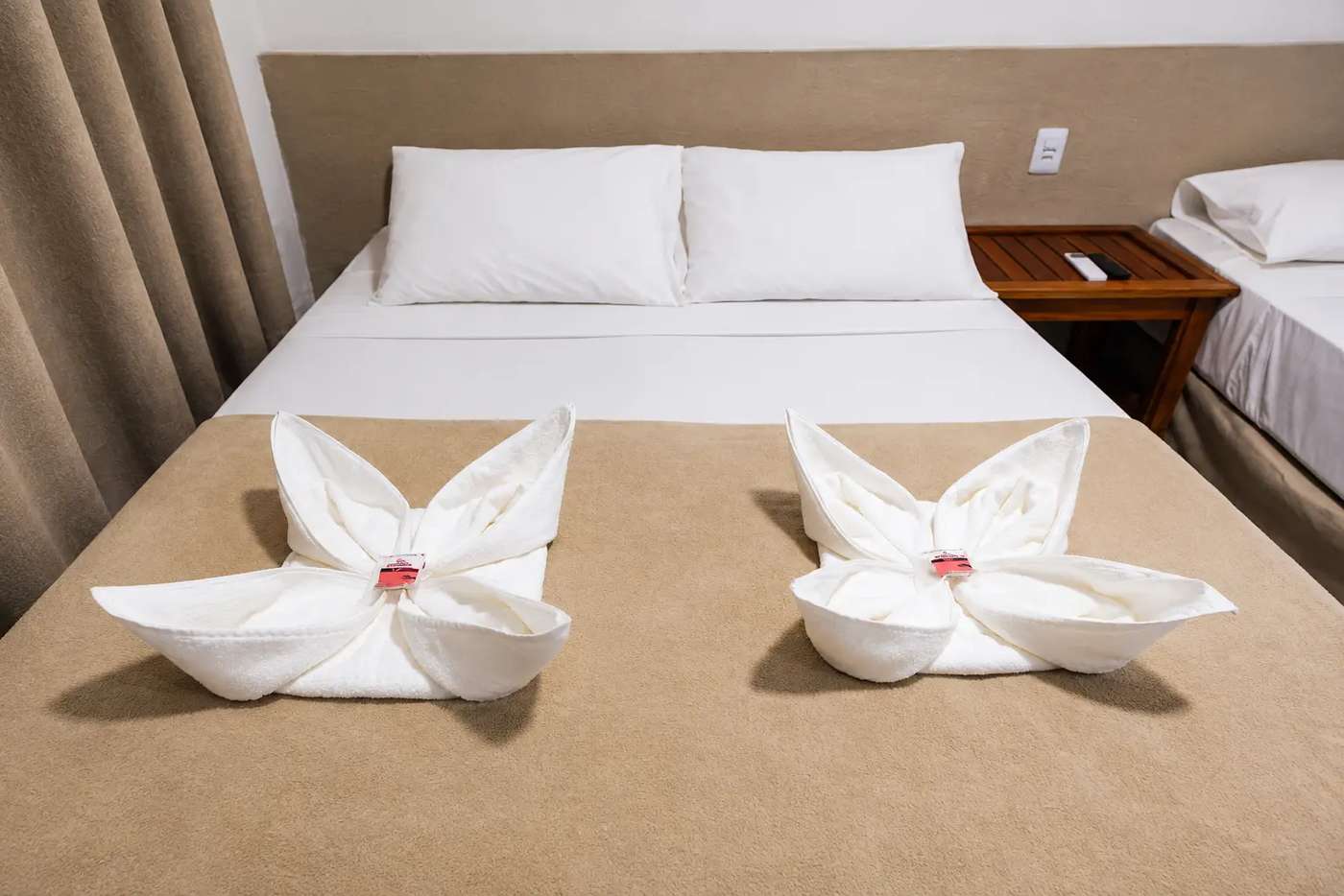 Toalhas dobradas sobre a cama do Quarto Duplo Standard