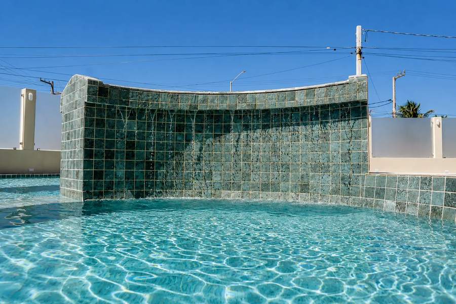Cascata de azulejos caindo na piscina ao ar livre